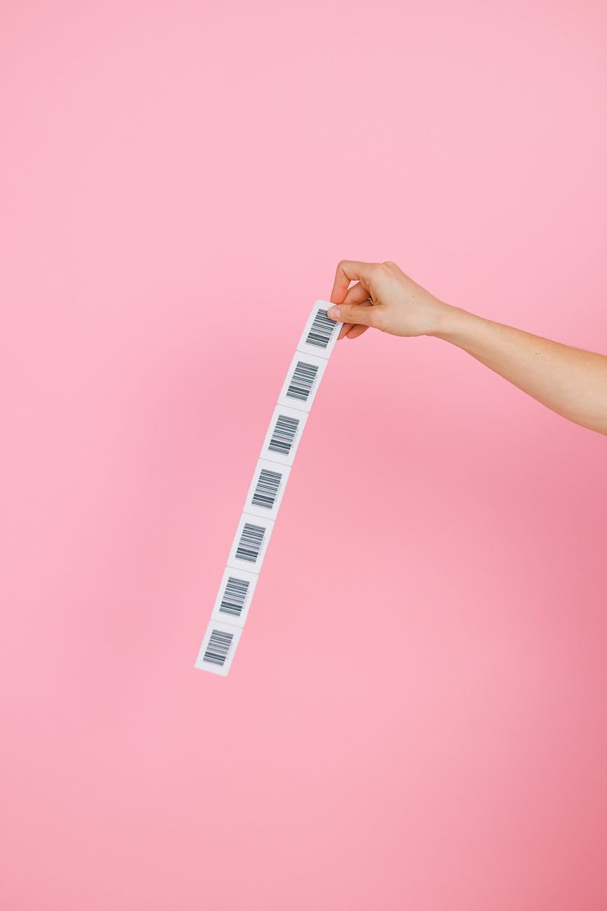 a person holding barcodes on pink background