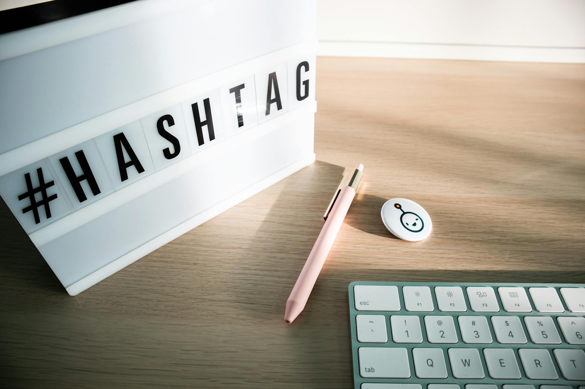 a keyboard light box with letters and pen lying on a desk